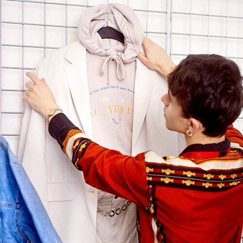 Male store employee arranging a clothing display