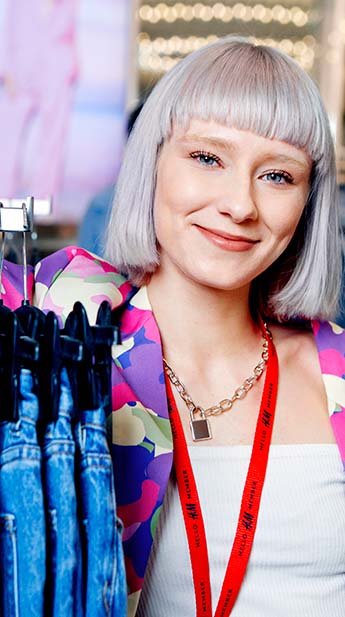 Female store working leaving on rail of denim