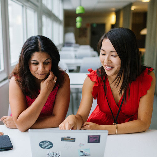 Two female colleagues looking at a laptop screen