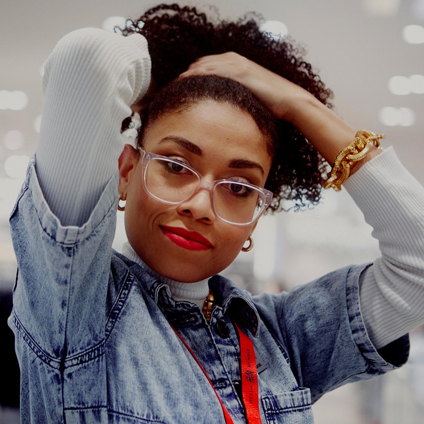 Employée d'un magasin se tirant les cheveux en arrière sur le visage.