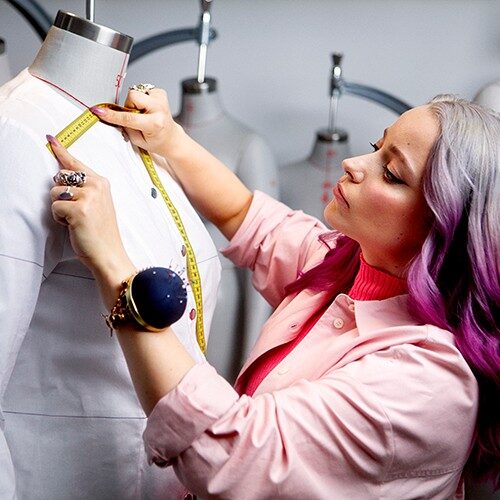 Female measuring a fabric sample placed on a mannequin