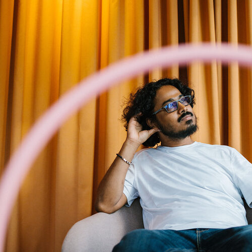 Male relaxing in a chair looking off camera